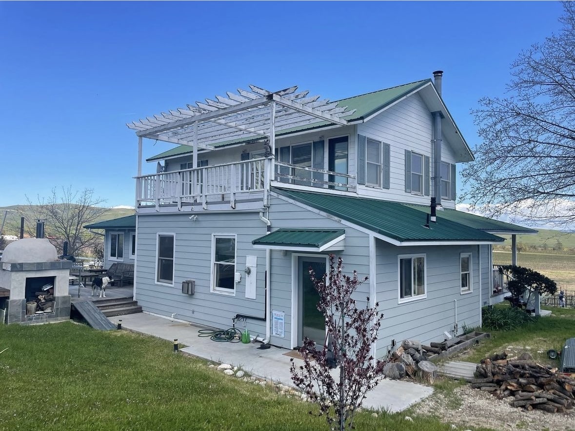 Two-storey light blue farmhouse repainted by Trombley Painting Company